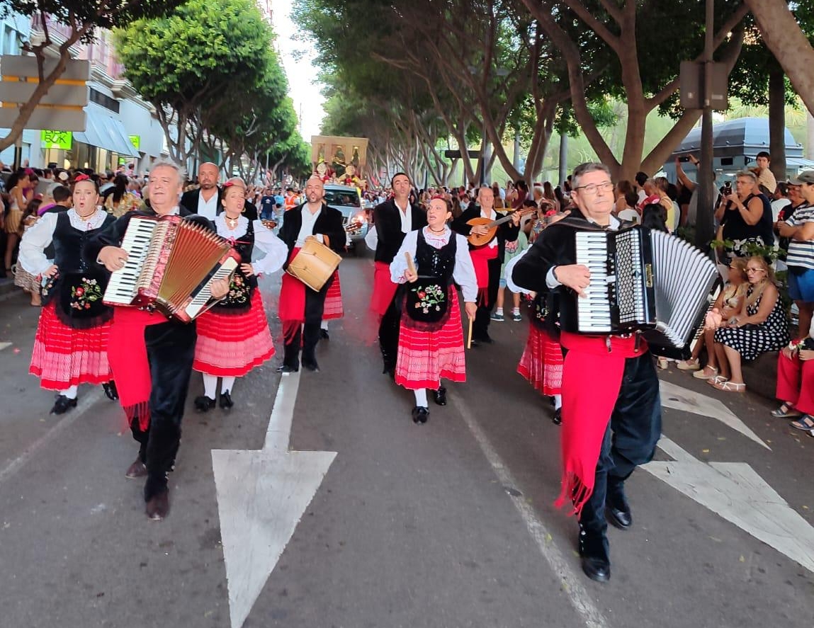 Dos integrantes de la asociación folclórica auxilian a una persona en el festival de Almería